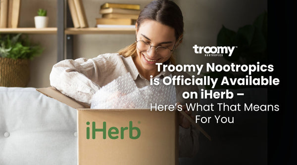woman smiling opening a cardboard box that says "iHerb" in green text