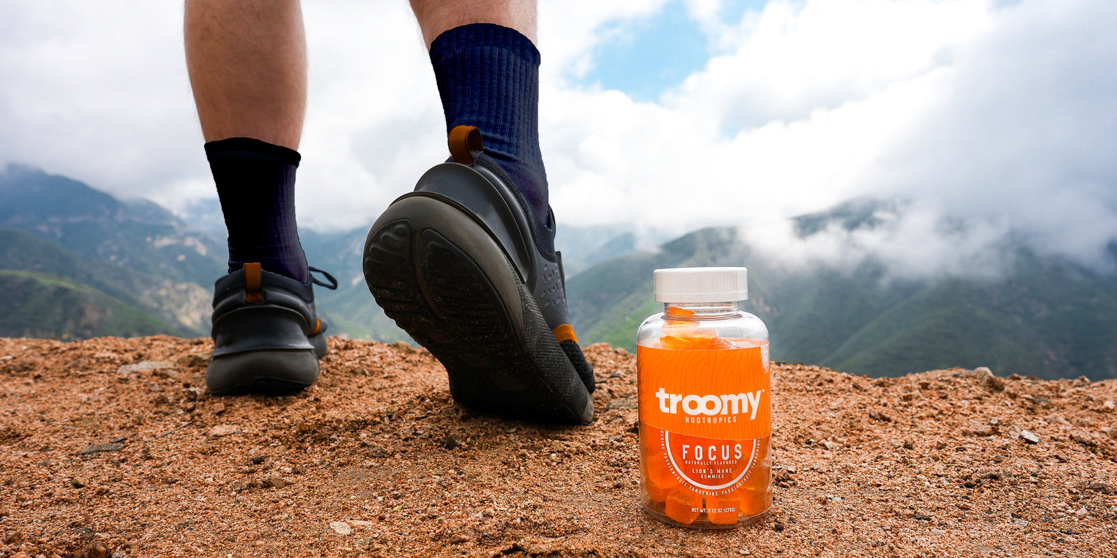 Hiking Habits - Focus Lion’s Mane Gummies - Tangerine Passionfruit  - Brain Support - Standing Next to60ct Jar - Troomy Nootropics in Whittier, CA