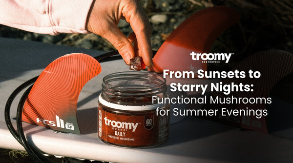 woman reaching into mushroom gummy jar resting on a surfboard at golden hour 
