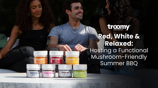 group of friends in their twenties sitting around a table smiling in the summertime